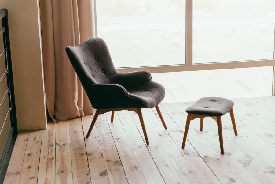 Upholstered footstool next to armchair for footstool cleaning